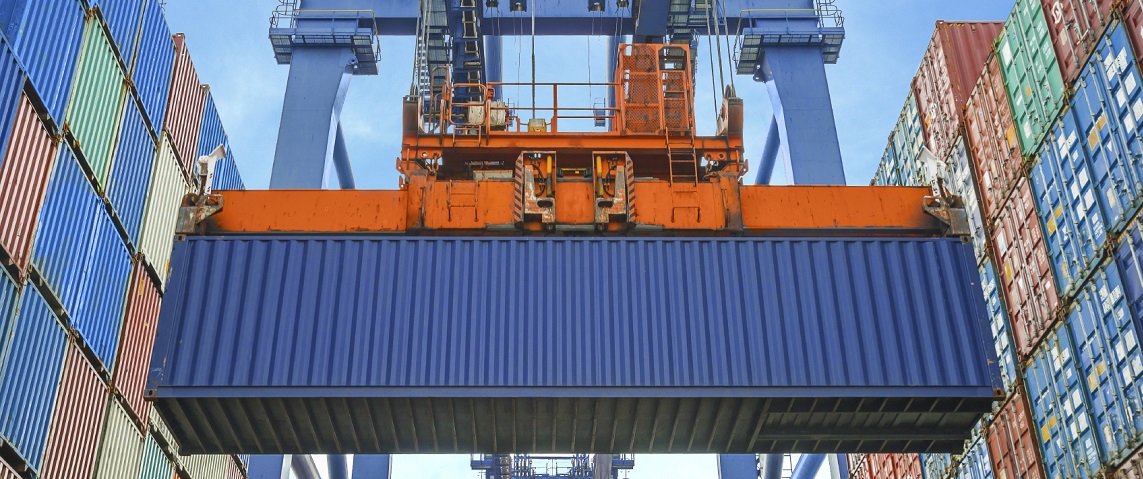 Shore crane loading containers in freight ship