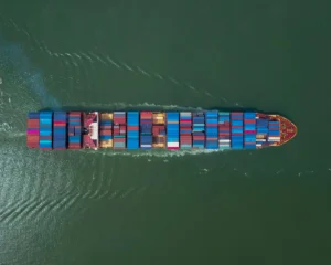 Sea Freight Vessel with Shipping Containers sailing - arial view