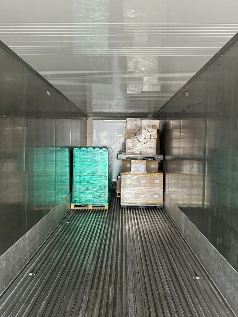 Inside a shipping container, pallets are stacked for importing from South Korea into the UK