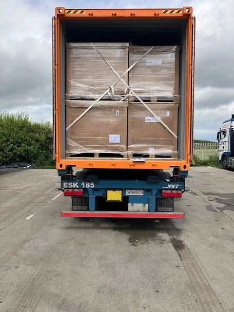 Open shipping container on a truck loaded with stacked pallets for sea freight from Japan to UK