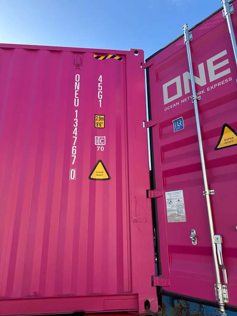 Pink shipping container with door open, side view, shipping from Thailand